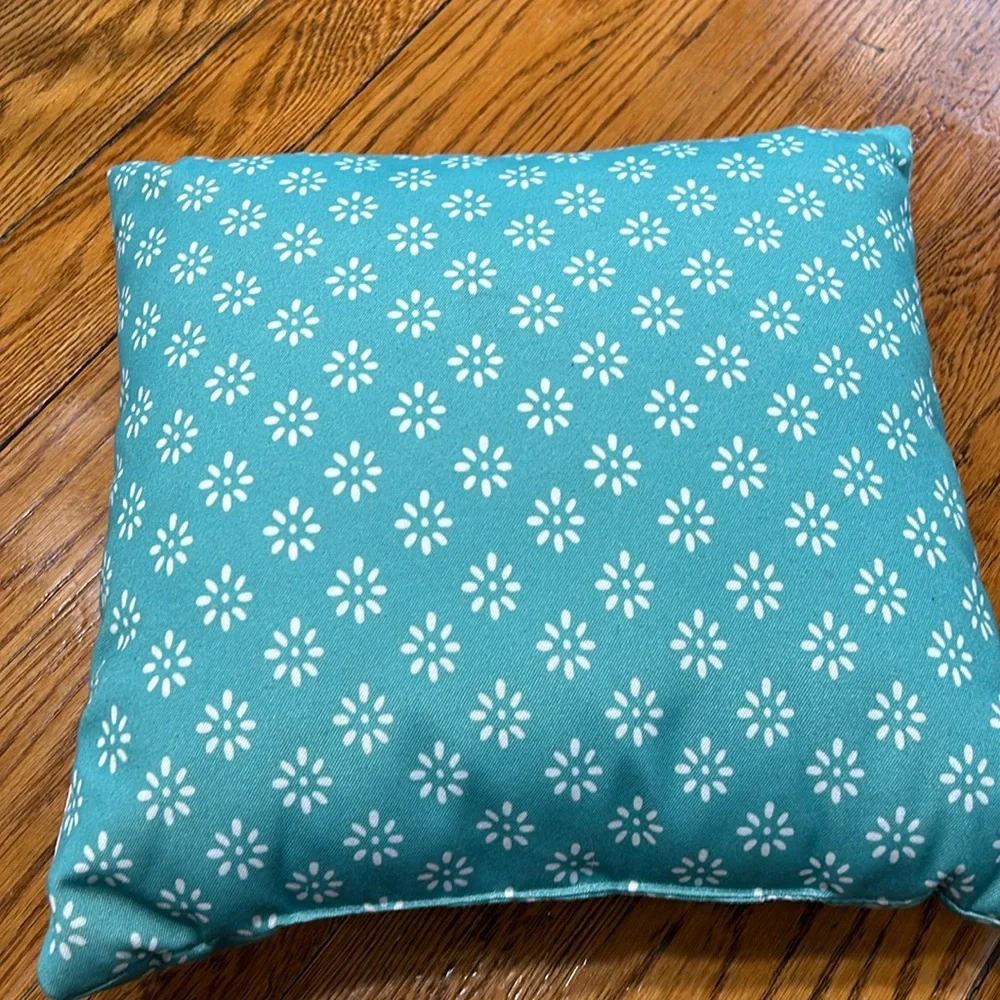 Aqua fabric pillow with hook and loop flamingo decoration.